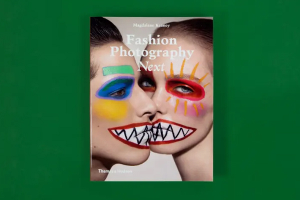 Two hands next to each other, lightly touching while resting on a car seat